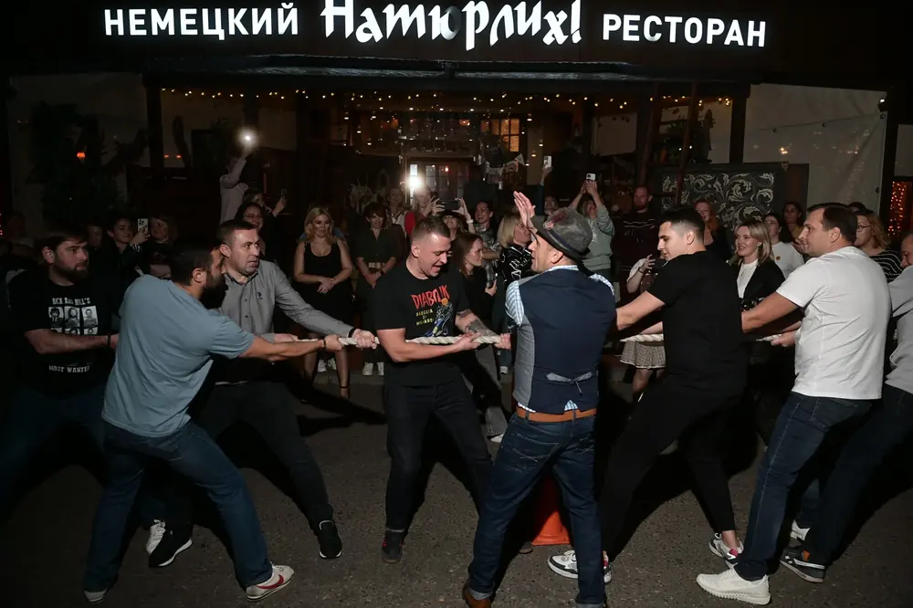 Гости за длинным столом на вечере в ресторане